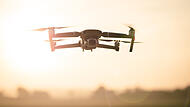 Drone like Mavic 2 Pro flying during sunset.