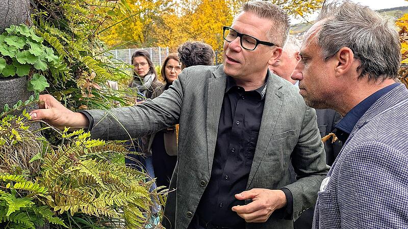 Gefässerie-Inhaber Achim Eilingsfeld (links) erläutert Bayerns Umweltminister Thorsten Glauber die modulare Bauweise der Fassadenbegrünung