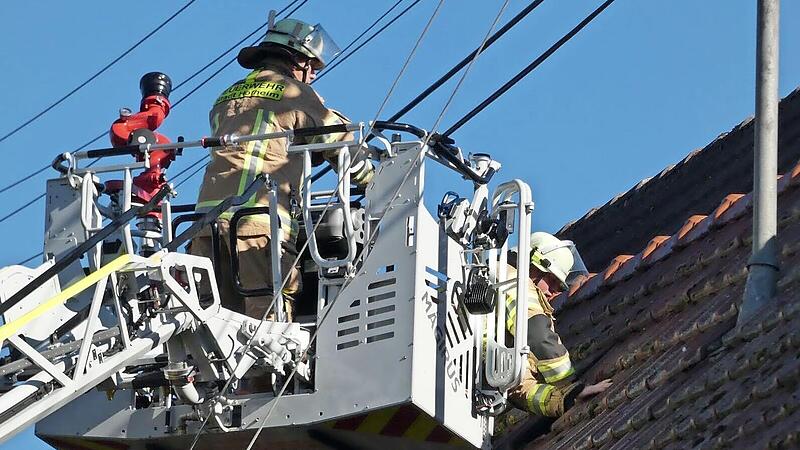 Mit Hilfe der Drehleiter wurde teilweise das Dach abgedeckt, um f&uuml;r Entl&uuml;ftung zu sorgen und den Wehrleuten einen besseren Einblick in die Lage zu verschaffen.