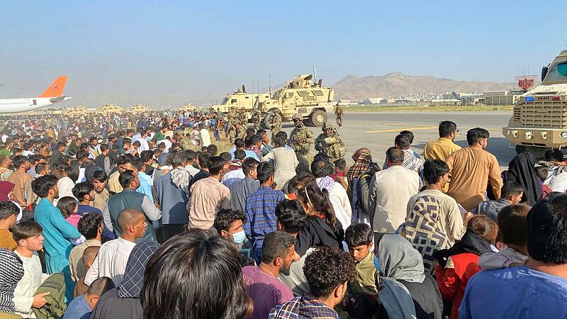 US-Soldaten bewachen eine Absperrung am internationalen Flughafen in Kabul, wo sich die Menschen drängen, die aus dem Land fliehen wollen. US-Soldaten bewachen eine Absperrung am internationalen Flughafen in Kabul, wo sich die Menschen drängen, die aus dem Land fliehen wollen.