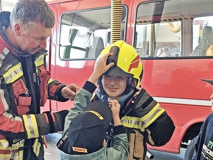 Der Schondraer Feuerwehr-Kommandant Christian Sch&uuml;ssler weist die Schulkinder in die Ausr&uuml;stung der Feuerwehrleute ein.