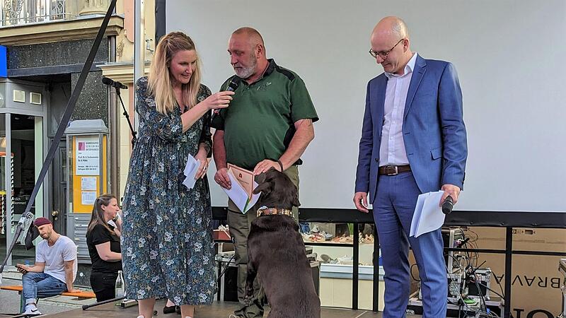 Steffen Schubert mit Labradorh&uuml;ndin Quendy (Gebrauchs- und Schutzhundeverein Bad Kissingen), hier mit Moderatorin Kathie Kleff, wurde von Oberb&uuml;rgermeister Dirk Vogel f&uuml;r den dritten Platz bei der Bayerischen Meisterschaft 2022 ausgezeichnet.