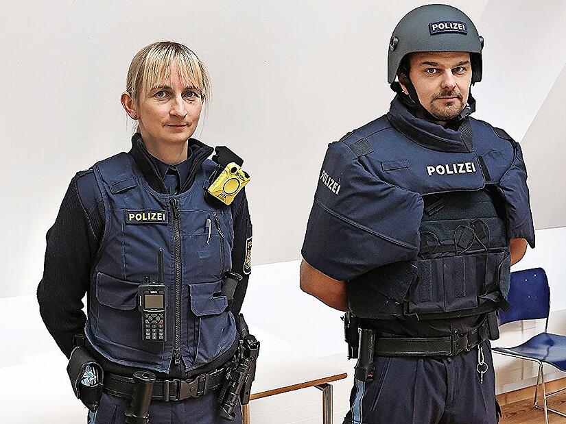 Julia Frohna in ganz normaler Einsatzausrüstung, Christian Fleischmann hat zur Demonstration die schwere ballistische Schutzweste „SK 4“ übergezogen und den schweren Helm aufgesetzt.
