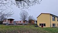 Noch stehen zwei Holzwagen im Garten des Kindergartens Premich als provisorische Unterkunft f&uuml;r die Hortkinder. Bald soll hier ein moderner Anbau entstehen