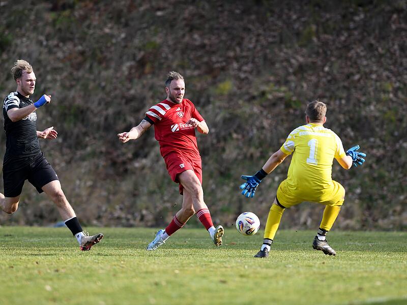 Der dreifache Trossenfurter Thorsten Schlereth (Mitte) schiebt den Ball am Schonunger  Torwart Ludwig Busse vorbei.