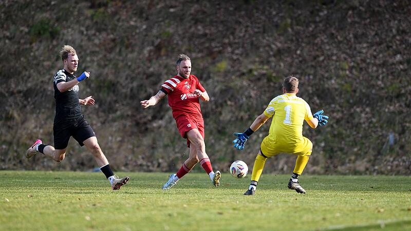 Der dreifache Trossenfurter Thorsten Schlereth (Mitte) schiebt den Ball am Schonunger  Torwart Ludwig Busse vorbei.