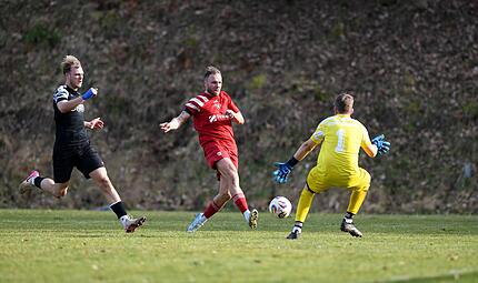 Der dreifache Trossenfurter Thorsten Schlereth (Mitte) schiebt den Ball am Schonunger  Torwart Ludwig Busse vorbei.