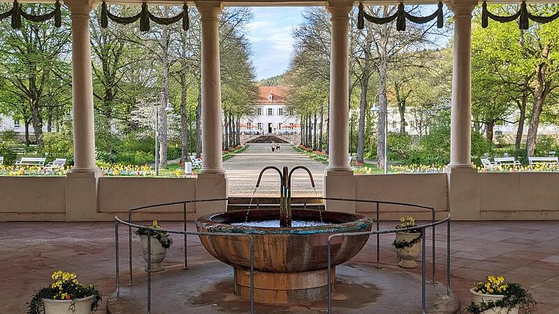 Der Balthasar-Neumann-Heilwasserbrunnen im Jubiläumsjahr 2024 mit Blick auf den Fürstenbau