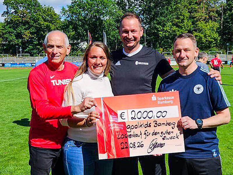 Am Rand des Fu&szlig;ballspiels des FC Eintracht Bamberg gegen den FC Sternstunden &uuml;berreichte Gastwirt Sebastian Linz (3. v. li.) 2000 Euro an den F&ouml;rderverein Goolkids. V. li.: Wolfgang Heyder (2. Vorstand goolkids), goolkids-Schriftf&uuml;hrerin Laura Stelzer, Linz und Landrat Johannes Maciejonczyk.