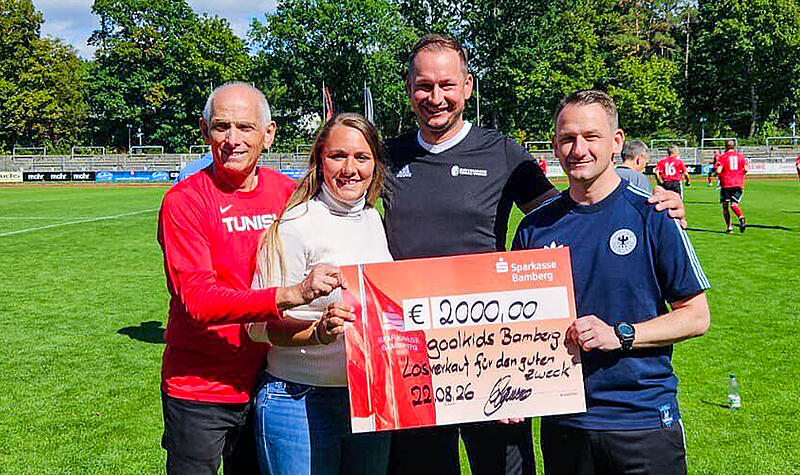 Am Rand des Fu&szlig;ballspiels des FC Eintracht Bamberg gegen den FC Sternstunden &uuml;berreichte Gastwirt Sebastian Linz (3. v. li.) 2000 Euro an den F&ouml;rderverein Goolkids. V. li.: Wolfgang Heyder (2. Vorstand goolkids), goolkids-Schriftf&uuml;hrerin Laura Stelzer, Linz und Landrat Johannes Maciejonczyk.