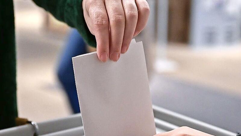 Ein W&auml;hler steckt bei einer Wahl seinen Wahlzettel in eine Urne. Bayernweit finden am 8. M&auml;rz Kommunalwahlen statt.