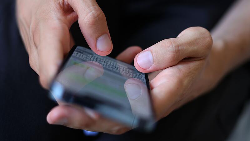 Mann tippt auf einem Smartphone eine WhatsApp Nachricht