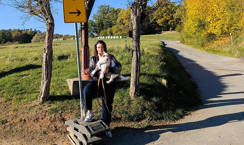 Anwohnerin Michaela Schneider steht mit ihrem Hund an der Umleitungsstrecke. Hinter dem geteerten Weg f&uuml;hrt f&uuml;hrt die Strecke weiter &uuml;ber eine Schotterpiste und am Feld entlang.
