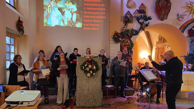 Heinrich Arnold (rechts) dirigiert den Kirchenchor &bdquo;Klangvoll&ldquo;. Die Gottesdienste werden live gestreamt, deshalb werden die Liedtexte f&uuml;r alle zum Mitsingen an die Wand projiziert. Seitdem, sagt Arnold verschmitzt, klinge auch der Gesang in der Ki...