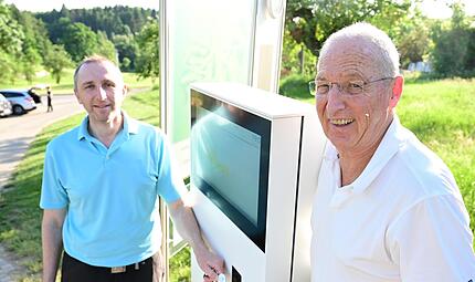 Clubmanager Ram&oacute;n M&auml;nnel (l.) und Spieler Christian G&uuml;rtner am digitalen Check-In beim Golfclub Erlangen.