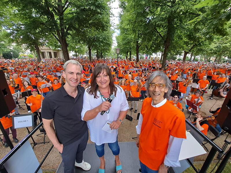 Intendant Alexander Steinbeis (von links), Redaktionsleiterin Susanne Will und Dirigent Kent Nagano machen ein Foto mit den Teilnehmerinnen und Teilnehmern.
