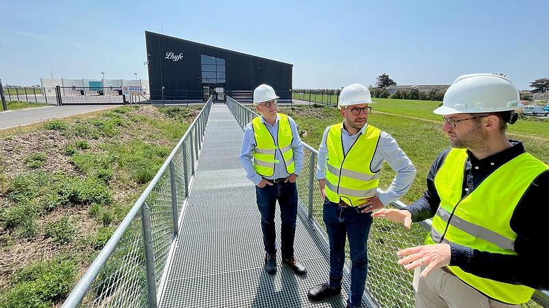 Vor der Werkhalle der Wasserstoffproduktion und (links im Hintergrund) der Verladestation f&uuml;r die speziellen Wasserstoff-Tank-Auflieger f&uuml;r Sattelschlepper (von links): Arnaud Deniel, Anthony Descloziers, Christophe Dubruque