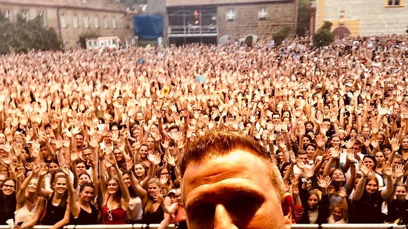 So erleben die Stars die Fanschar in einem mit 4500 Zuschauern ausverkauften Schlosshof von Eyrichshof. J&ouml;rg Wagner von Radio Bamberg, der die Anmoderation &uuml;bernahm, knipste dieses Selfie vor &uuml;berw&auml;ltigender Kulisse bei der Anmoderation des Auftritts von Wincent Weiss im Jahr 2019.