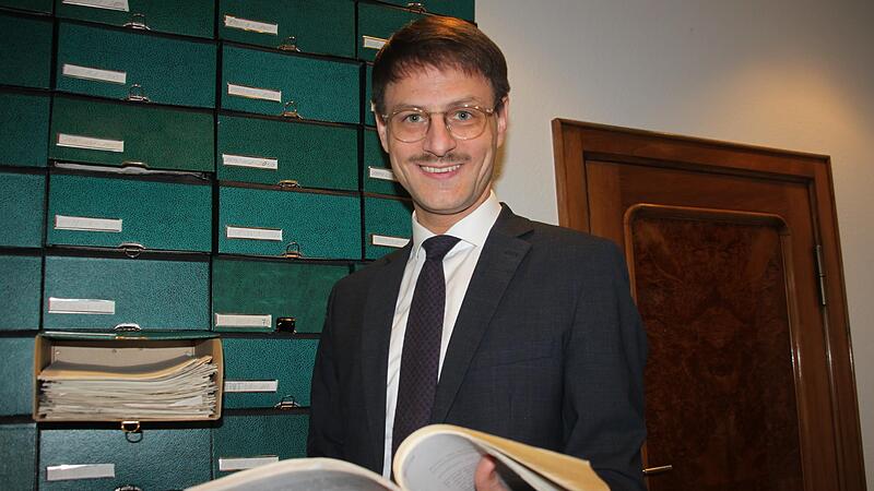 Dr. Fabian Eike Fla&szlig;hoff ist der neue Notar von Burgkunstadt. Aus einem Urkundenkasten hat er sich ein altes Dokument herausgeholt.