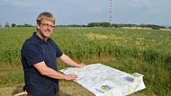 Tobias Gruber legt die neue Wanderkarte auf der Infotafel vor der Alexandrinenhütte auf.