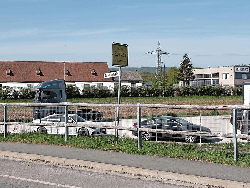 In der Bahnhofstra&szlig;e in Eggolsheim auf dem unbebauten Grundst&uuml;ck hinter den Fahrzeugen soll ein neuer Rewe-Markt entstehen.