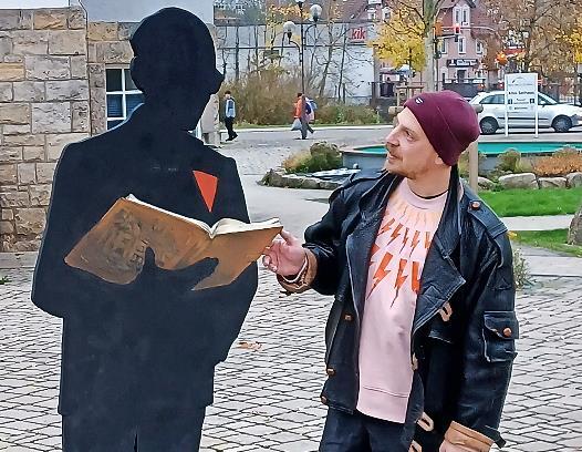 Emanuel Guarascio, Kunsterzieher am Franz-Miltenberger-Gymnasium, präsentiert die Schattenrissfigur von Ernst Putz auf dem Alten Rathausplatz.