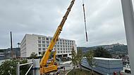 Zwei Kräne sind nötig, um die Module vom Wendekreis über die Baustelle aufs Dach zu kriegen. Zwei Kräne sind nötig, um die Module vom Wendekreis über die Baustelle aufs Dach zu kriegen.