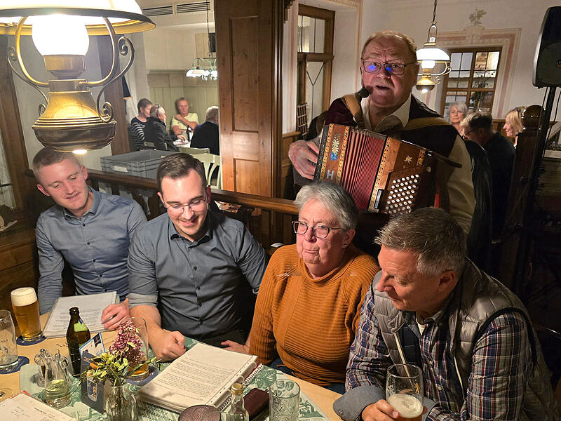 Robert Treuheit mit seiner Ziehharmonika hinter einigen begeisterten Sängern in Neuhaus.