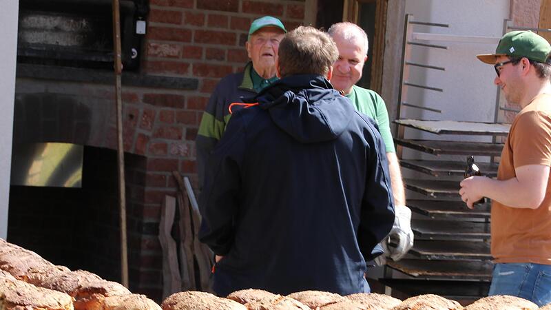 Erfahrene Helfer leisteten Akkordarbeit beim Brotbacken im neuen Schlossbackh&auml;usle. Den ersten Laib erhielten Sponsoren und Ehrenamtliche gratis.