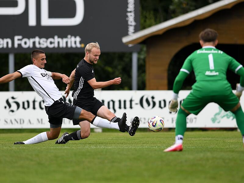 Fabian Stingl von der SG Obertheres zieht ab, während die Grätsche des Sanders Sebastian Krines  zu spät kommt. Torhüter Maximilian Müller ist aber nicht zu überwinden.  Mit 4:0 setzte sich die Korbmacher-Reserve am Ende durch.