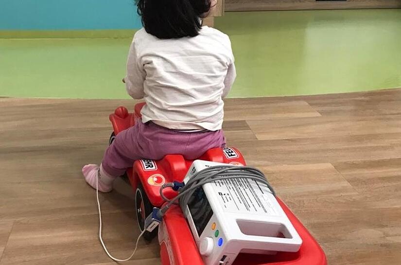 Mobil trotz &Uuml;berwachungsger&auml;t. Ein Bobbycar-Anh&auml;nger dient hier als kleiner Transporter.B&auml;renfamilie