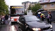 Elterntaxi gegen Schulbus: Der dunkle BMW blockiert die Haltestelle, Polizist Florian Heuring konfrontiert den Fahrer. Elterntaxi gegen Schulbus: Der dunkle BMW blockiert die Haltestelle, Polizist Florian Heuring konfrontiert den Fahrer.