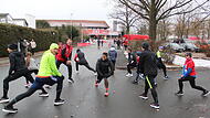 Mit Dehnungs&uuml;bungen bereitet sich diese Gruppe gewissenhaft auf den Hauptlauf vor.  Alle Bilder vom Staffelsteiner Silvesterlauf gibt es zum Durchklicken in unserer Bildergalerie.