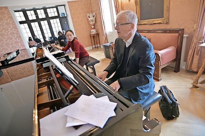 Arnulf von Arnim spielt mit seinem Meisterkurs in der Bibliothek von Haus Marteau.