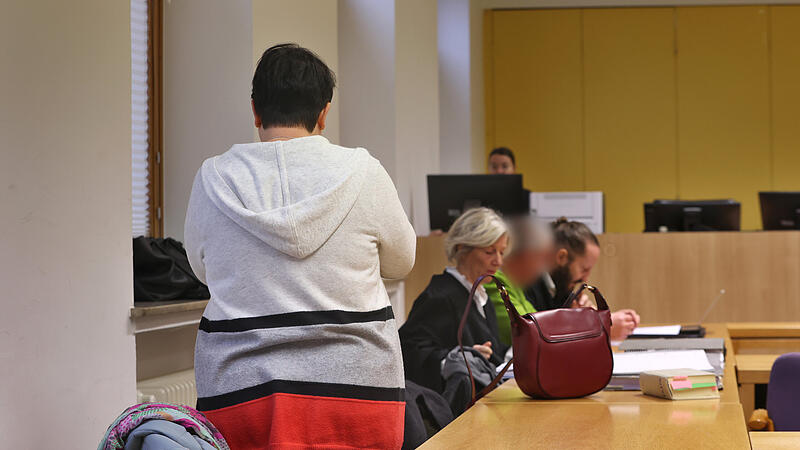 Eine angeklagte Frau (l) und ihr ebenfalls angeklagter Ehemann (3.v.l) stehen und sitzen mit ihren Anwälten in einen Gerichtssaal im Landgericht. Knapp zwei Jahre nach dem mutmaßlichen Hungertod ihrer Tochter haben die angeklagten Eltern die Verantwortung für das Geschehen übernommen.  Laut Staatsanwaltschaft infizierte sich deren 16-Jährige Tochter kurz vor ihrem Tod im Dezember 2022 mit dem Coronavirus und litt an einer Magen-Darm-Infektion.