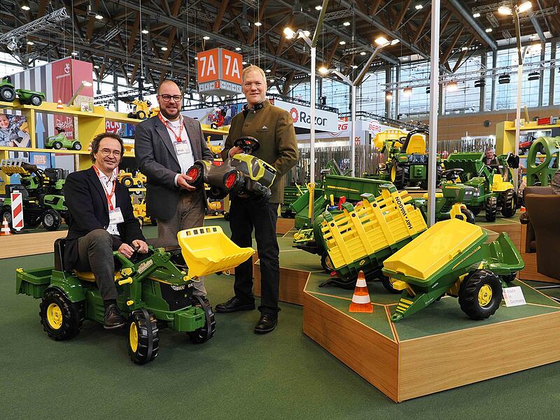 Rolly Toys aus Neustadt steht f&uuml;r hochwertige Kinderfahrzeuge, besonders aus der Landwirtschaft. Das Design stimmt mit den &bdquo;gro&szlig;en Kollegen&ldquo; &uuml;berein. IHK-Pr&auml;sident Dr. Andreas Engel versucht sich als Treckerfahrer, hinten Frank Schneider und Landrat Sebastian Straubel.