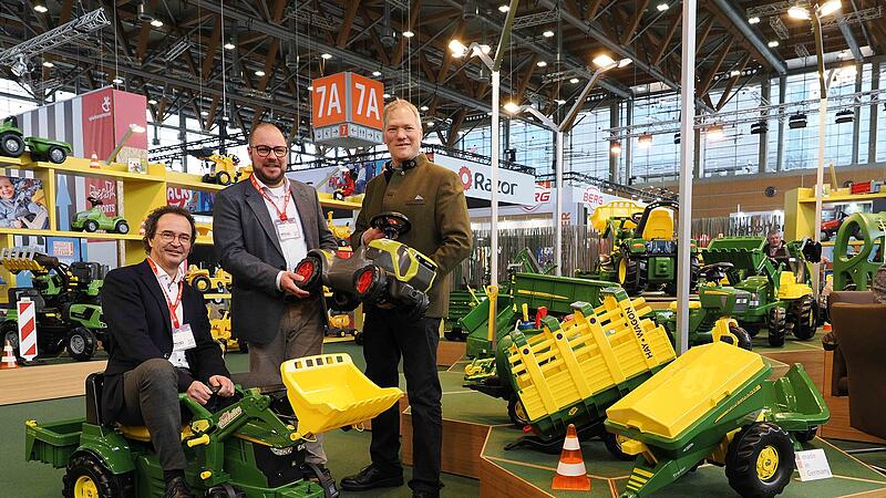 Rolly Toys aus Neustadt steht f&uuml;r hochwertige Kinderfahrzeuge, besonders aus der Landwirtschaft. Das Design stimmt mit den &bdquo;gro&szlig;en Kollegen&ldquo; &uuml;berein. IHK-Pr&auml;sident Dr. Andreas Engel versucht sich als Treckerfahrer, hinten Frank Schneider und Landrat Sebastian Straubel.