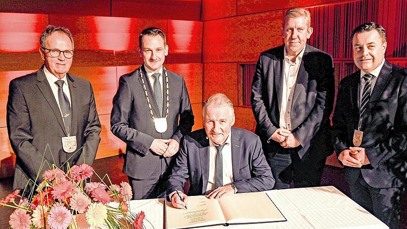 Der Bundesliga-Schiedsrichter und Festredner Lutz Wagner tr&auml;gt sich ins Goldene Buch der Marktgemeinde Burgebrach ein. Ihm schauen &uuml;ber die Schulter (von links): Dritter B&uuml;rgermeister Peter Ludwig, Erster B&uuml;rgermeister Johannes Maciejonczyk, MdB A...