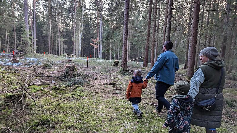 Idyllischer Platz: Nicole M&uuml;ller mit Sohn Emil und Jonas Duscher mit Sohn Vincent unterwegs zum k&uuml;nftigen Waldkindergarten in der N&auml;he des Flugplatzes. Die rot gekennzeichneten Pfosten markieren den Platz, an dem die Schutzh&uuml;tte stehen soll.