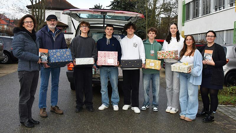 Schulleiterin Kristina Kurz (links) und Lehrerin Maren Paltian (rechts) freuen sich mit einigen Sch&uuml;lern &uuml;ber die gro&szlig;e Hilfsbereitschaft bei der &Uuml;bergabe der Pakete an Ottmar Deppisch.