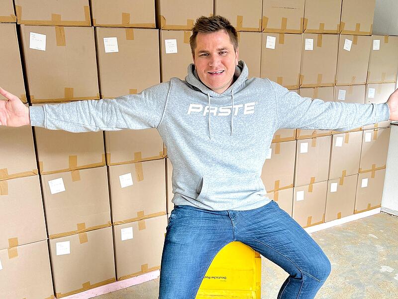 Pascal Kümmert sitzt vor einem Stapel Pakete. Pascal Kümmert sitzt vor einem Stapel Pakete.