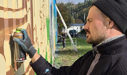 Alexander D&uuml;mke sprayt gerade einen Baum auf die Hallenwand. Marco Mei&szlig;ner
