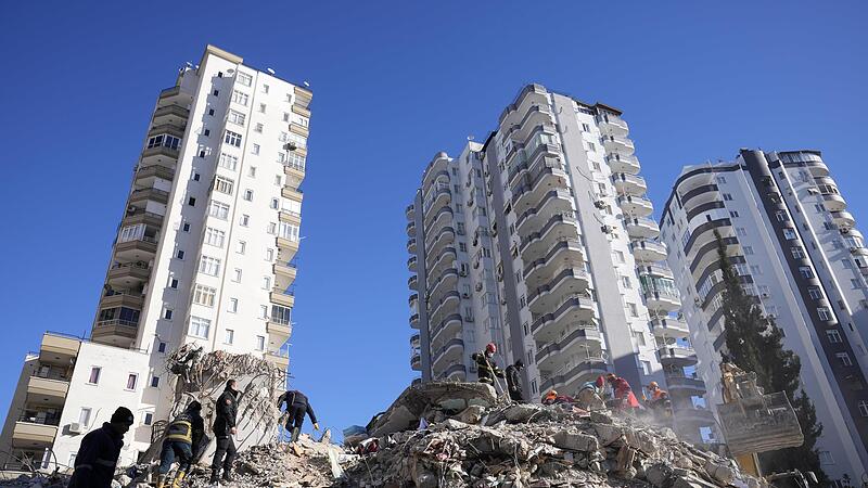 Notfallteams suchen in Adana nach Menschen in den Tr&uuml;mmern eines zerst&ouml;rten Geb&auml;udes.