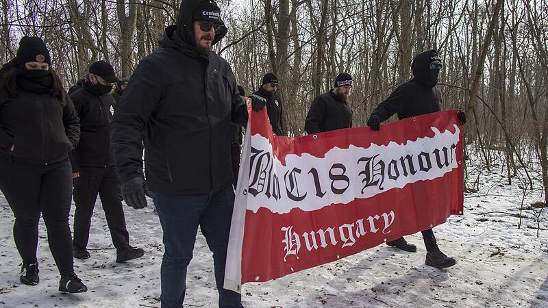Budapest, Tag der Ehre, Neonaziaufmarsch Hanna S Diese Neonazis marschierten ebenfalls beim "Tag der Ehre" in Budapest am 11. Februar 2023 auf. Auf ihrer Fahne steht "Blood" (Blut), "Honour" (Ehre) und "Combat 18". Die Zahlen eins und acht stehen im Alphabet für A und H. Somit kann übersetzt werden, dass hier die "Kampfgruppe Adolf Hitler" unterwegs war. Deren Mitglieder trafen sich auf dem Normafa-hügel, um von dort hinunter zur Budaer Burg zu wandern.