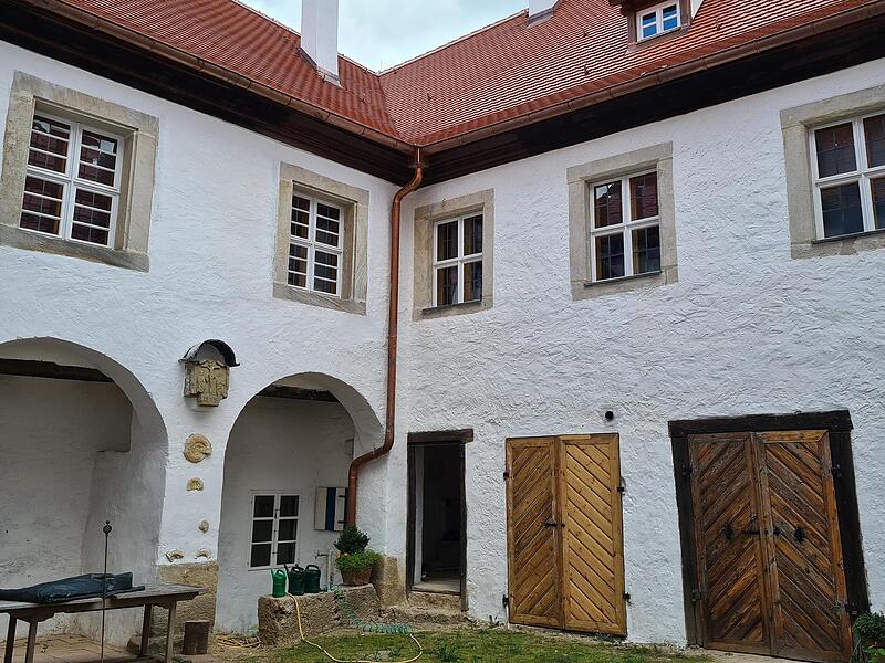 Der Innenhof von Schloss Hundshaupten zeigt sich mit sechsmal gekalkten W&auml;nden, neuen Ziegeln und alten Fenstern, innen mit neuem Glas.Forchheim & Fr&auml;nkische Schweiz