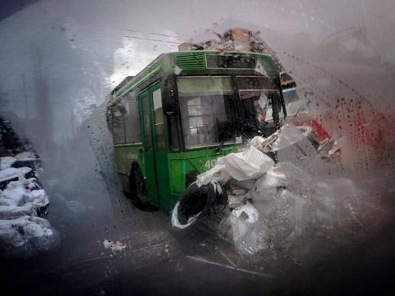 Eine Barrikade aus Straßenbahnen, Bussen und Sandsäcken ist durch das Fenster eines Autos im nördlichen Teil von Kiew zu sehen.