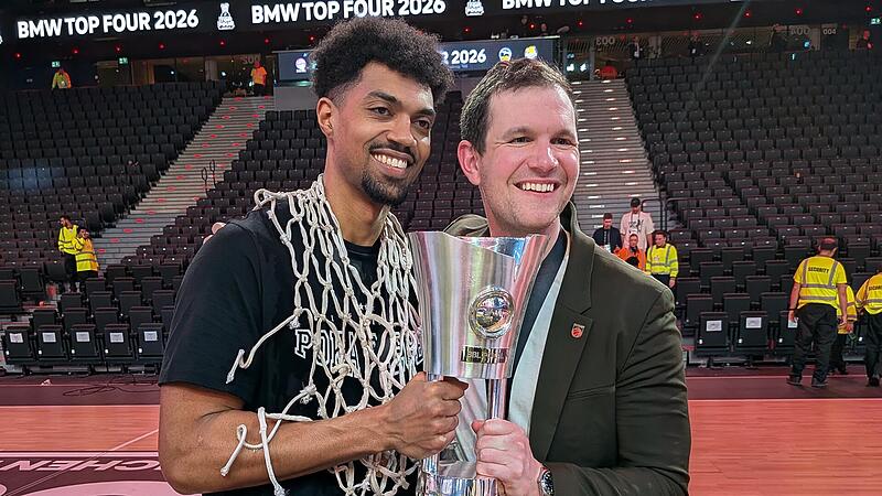 Strahlten mit dem Pott in den H&auml;nden um die Wette: Baskets-Kapit&auml;n Ibi Watson (links) und Philipp H&ouml;hne.