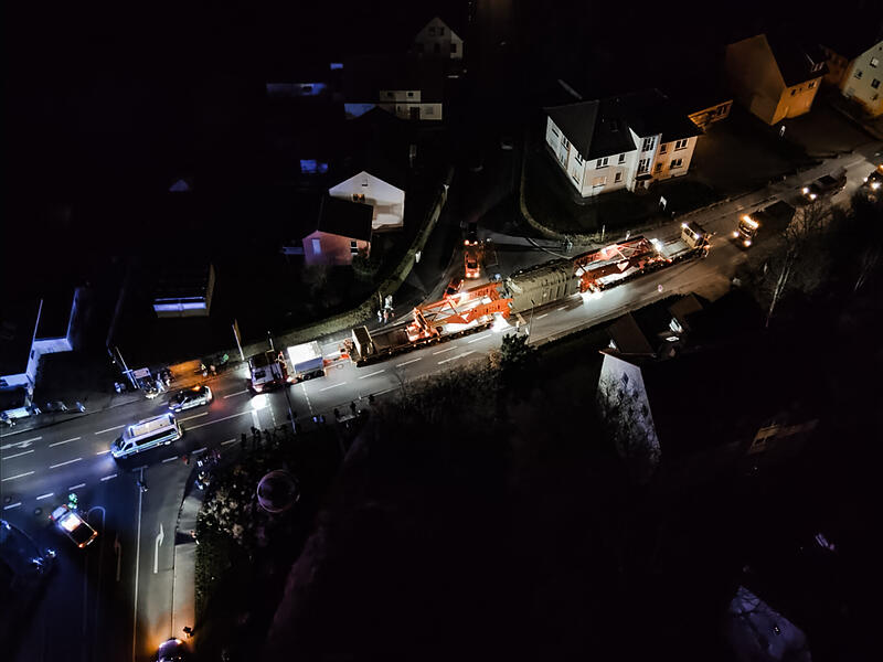 Der Schwertransport wirkt wie ein leuchtender Lindwurm in der Nacht.