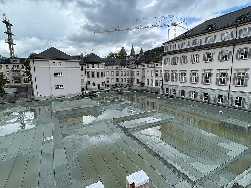 Blick auf den hinteren Bereich des Grundst&uuml;cks Richtung Kurhausbad und Neumannfl&uuml;gel. Die gro&szlig;e Fl&auml;che wird ein 1600 Quadratmeter gro&szlig;er Teich mit Pavillon im Wasser, der &uuml;ber Stege erreicht wird.
