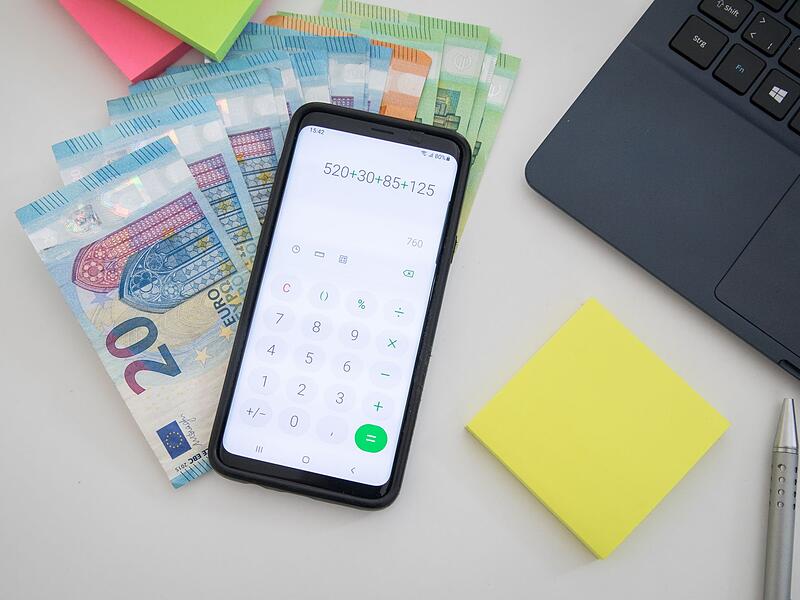 Symbolbild: Geld, Taschenrechner und Laptop stehen f&uuml;r die Haushaltsplanung und die finanziellen Entscheidungen in Zeitlofs f&uuml;r das Jahr 2025.